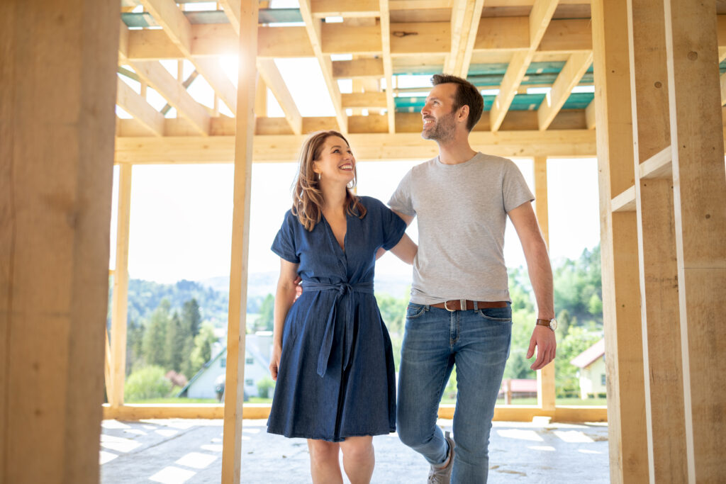 Wife and husband visiting building site of their new house with construction in background